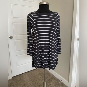 Dark gray tunic, longer in the back. Has criss-cross pattern on the shoulders.